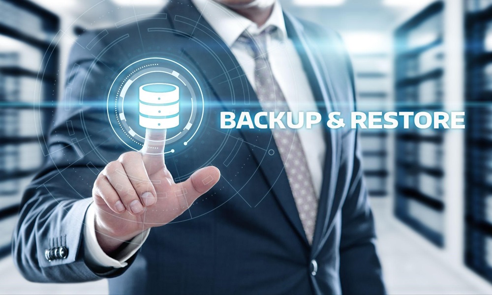 Businessman pushing virtual button labelled backup and restore